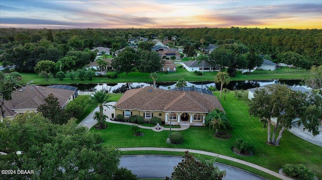 aerial view at dusk featuring a water view