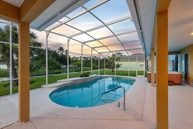 pool at dusk featuring glass enclosure, a patio area, and a yard