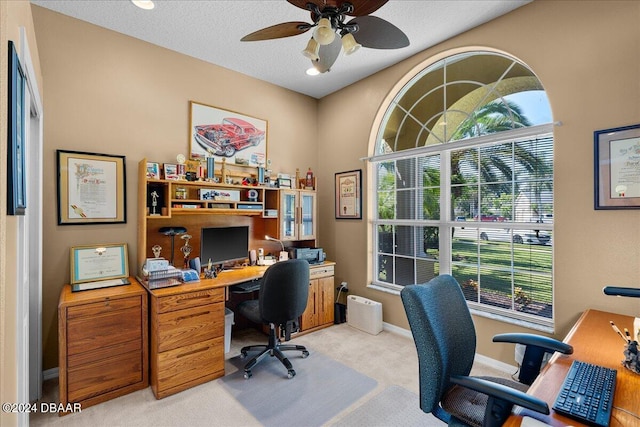 office area featuring a textured ceiling, light colored carpet, and ceiling fan