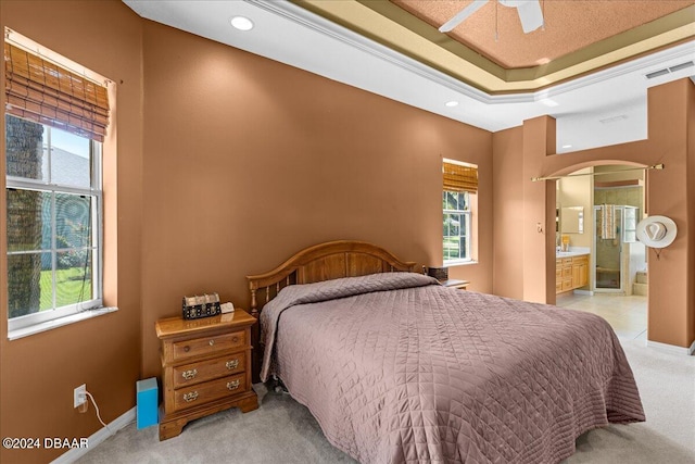 carpeted bedroom with ceiling fan and ensuite bath