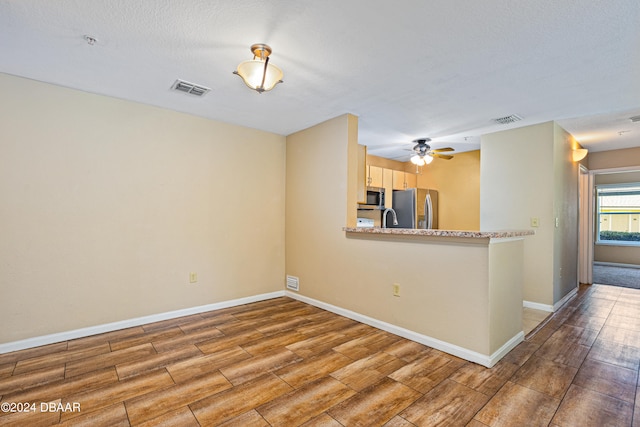 spare room with ceiling fan, wood-type flooring, a textured ceiling, and sink