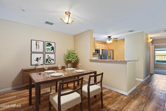 empty room with a textured ceiling, light hardwood / wood-style flooring, and ceiling fan