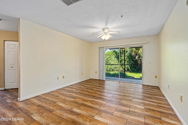 940 Village Trl Unit 6-102, Port Orange, FL 32127 - unfurnished room featuring wood finished floors, ceiling fan, a textured ceiling, and baseboards