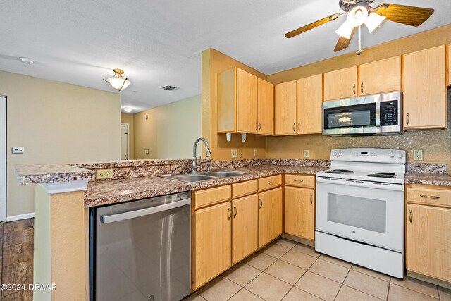 940 Village Trl Unit 6-102, Port Orange, FL 32127 - kitchen featuring stainless steel appliances, a sink, a peninsula, and light brown cabinets