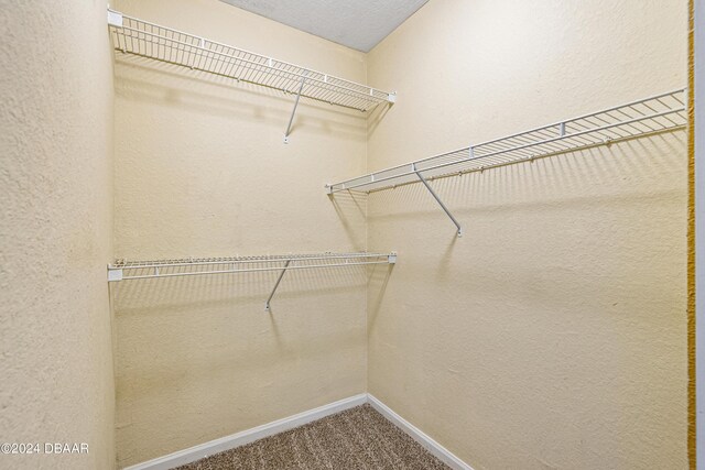 carpeted empty room with a textured ceiling and ceiling fan