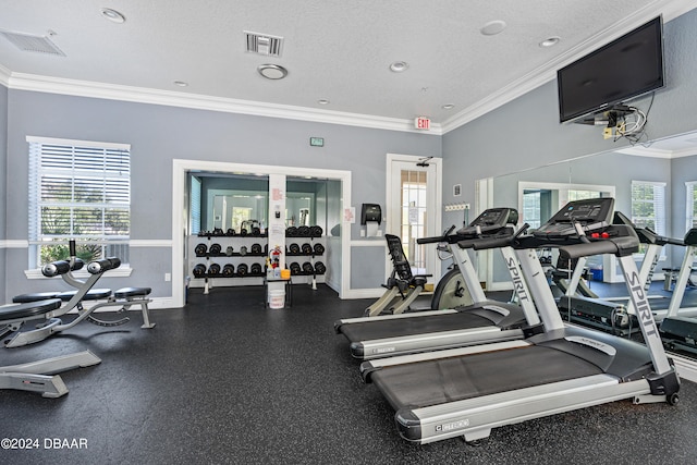 gym featuring a textured ceiling and ornamental molding