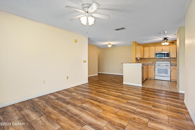 940 Village Trl Unit 6-102, Port Orange, FL 32127 - kitchen featuring electric range, stainless steel microwave, a ceiling fan, open floor plan, and light brown cabinets