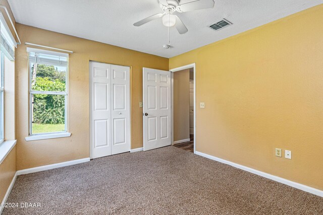 940 Village Trl Unit 6-102, Port Orange, FL 32127 - unfurnished bedroom with carpet floors, baseboards, a closet, and a ceiling fan