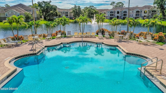 view of swimming pool featuring a patio and a water view