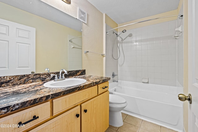 full bathroom featuring toilet, tile patterned floors, a textured ceiling, tiled shower / bath combo, and vanity