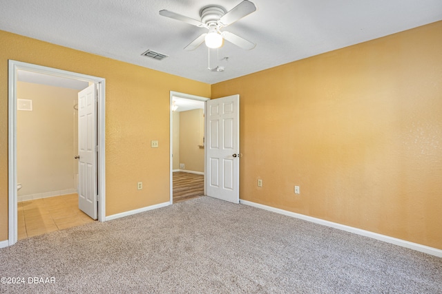 unfurnished bedroom with light colored carpet and ceiling fan