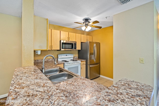 kitchen with sink, kitchen peninsula, appliances with stainless steel finishes, light brown cabinetry, and ceiling fan