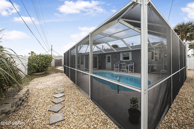 view of swimming pool featuring a patio and glass enclosure