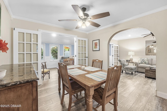 dining room with ornamental molding, light hardwood / wood-style floors, french doors, and ceiling fan