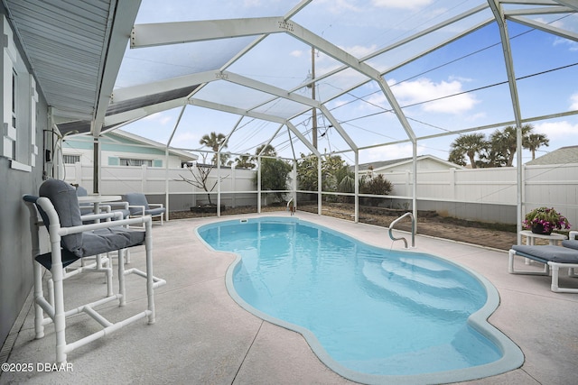 view of swimming pool featuring a patio area and glass enclosure