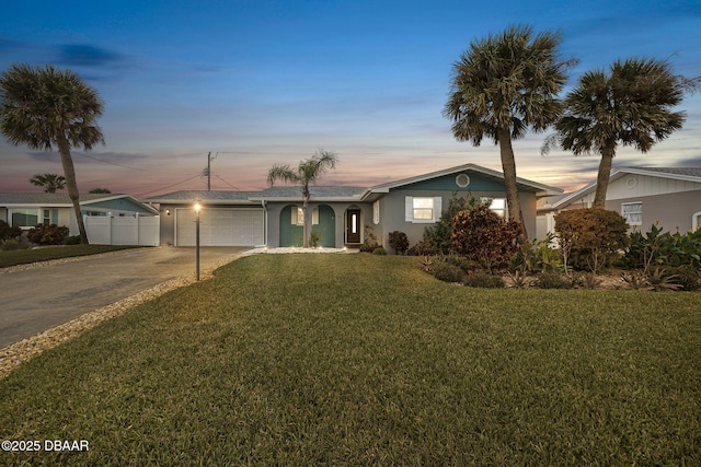 ranch-style home featuring a garage and a yard