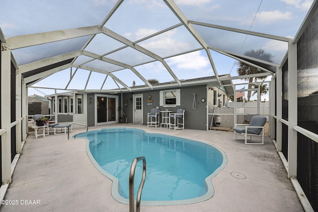 view of pool with glass enclosure and a patio area