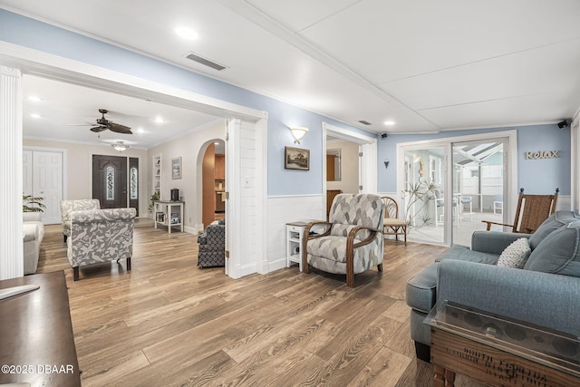 living room featuring hardwood / wood-style floors, ornamental molding, and ceiling fan