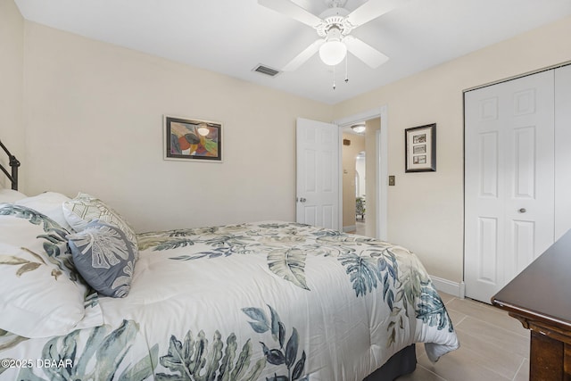 bedroom with ceiling fan, tile patterned floors, and a closet