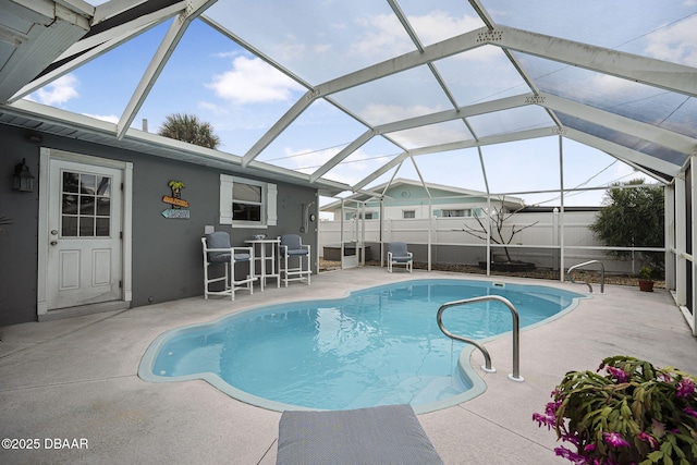 view of swimming pool featuring a patio and glass enclosure