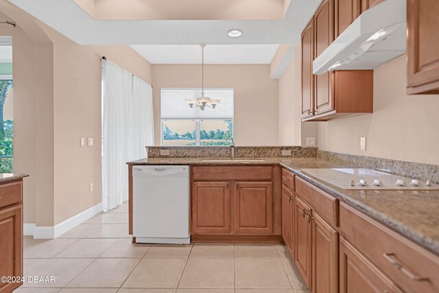 kitchen with range hood, white appliances, light tile patterned floors, sink, and a chandelier