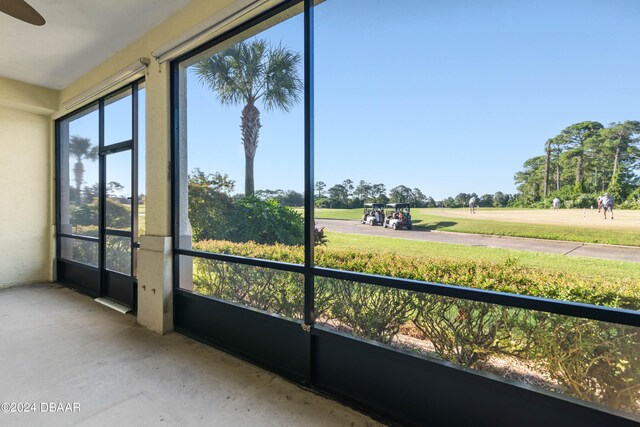 unfurnished sunroom with ceiling fan