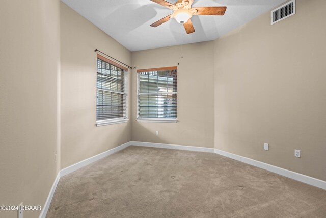 empty room featuring light colored carpet and ceiling fan