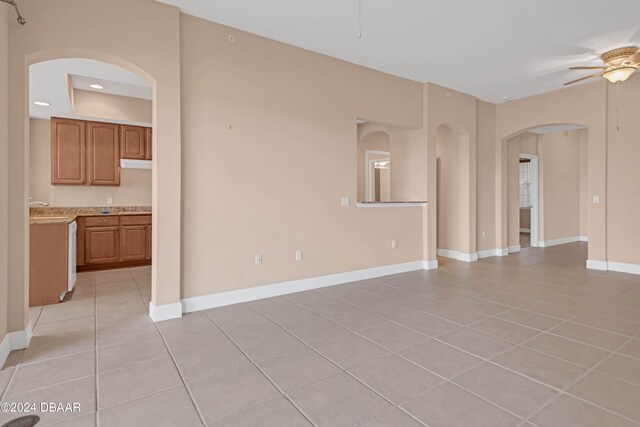 unfurnished living room featuring light tile patterned floors and ceiling fan