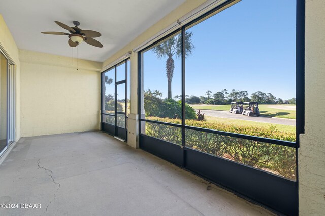 unfurnished sunroom featuring ceiling fan