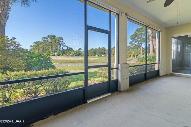 unfurnished sunroom featuring ceiling fan