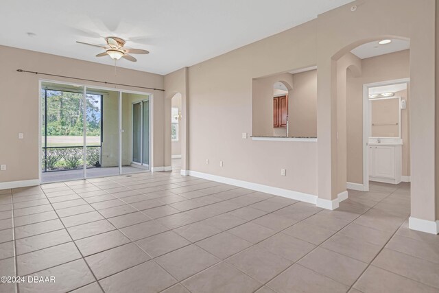 tiled spare room with ceiling fan