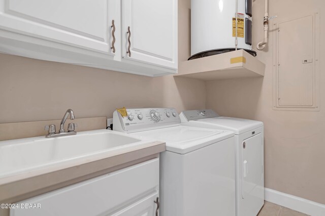 washroom featuring cabinets, light tile patterned flooring, sink, washer and clothes dryer, and electric panel