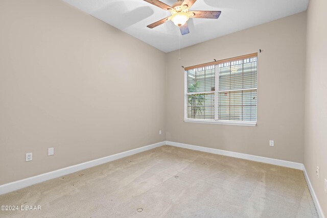 empty room with ceiling fan and light carpet