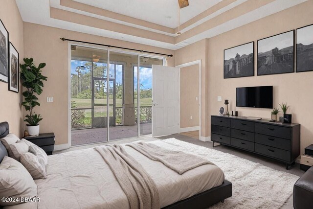 bedroom featuring a raised ceiling and access to outside