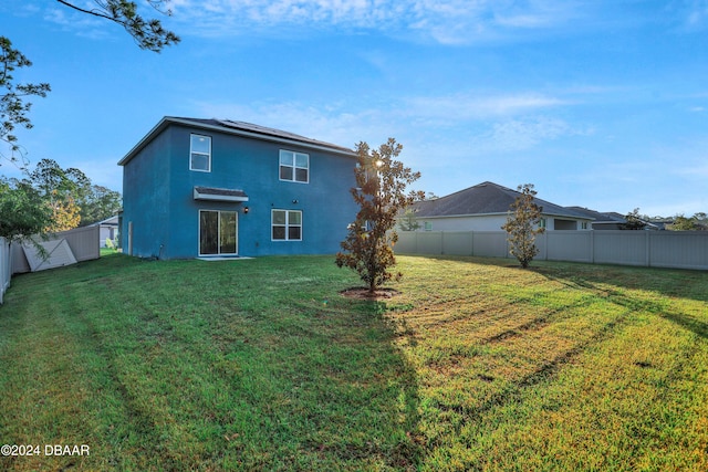 rear view of property with a yard