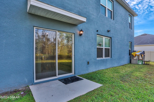 view of exterior entry with a lawn