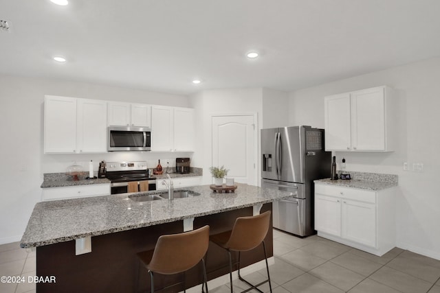 kitchen featuring white cabinets, a center island with sink, appliances with stainless steel finishes, and sink