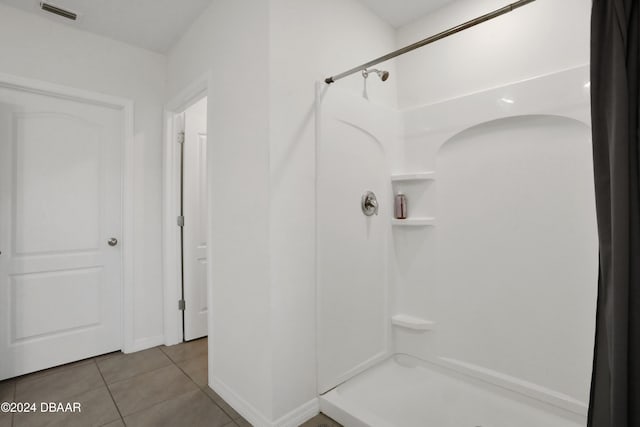 bathroom with a shower and tile patterned flooring