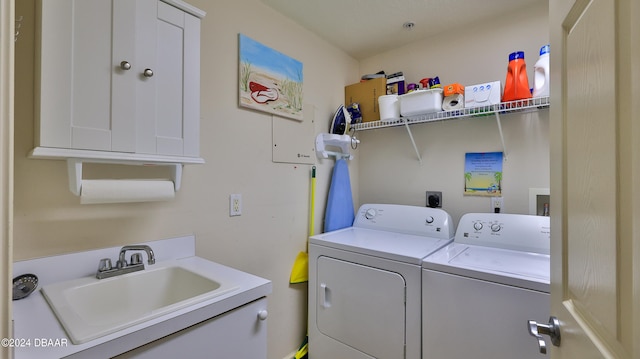 laundry room with cabinets, sink, and washer and dryer