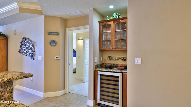 2403 S Atlantic Ave Unit 1210, Daytona Beach Shores, FL 32118 - indoor dry bar with wine cooler, baseboards, a textured ceiling, light carpet, and light tile patterned floors