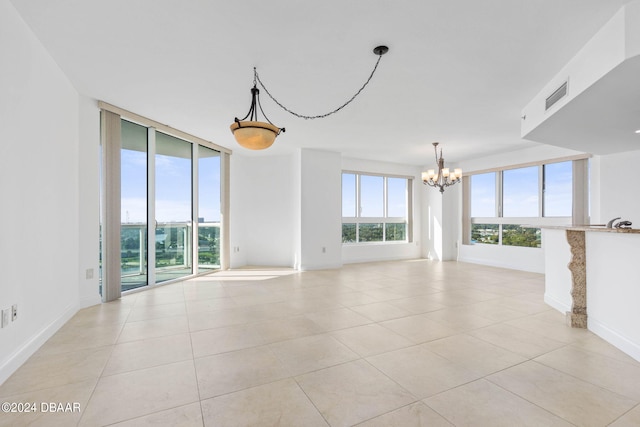 unfurnished living room with light tile patterned floors and an inviting chandelier