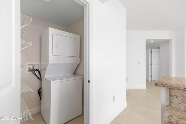 washroom featuring stacked washer and dryer and light tile patterned floors