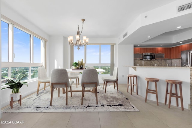 tiled dining area with a chandelier and plenty of natural light