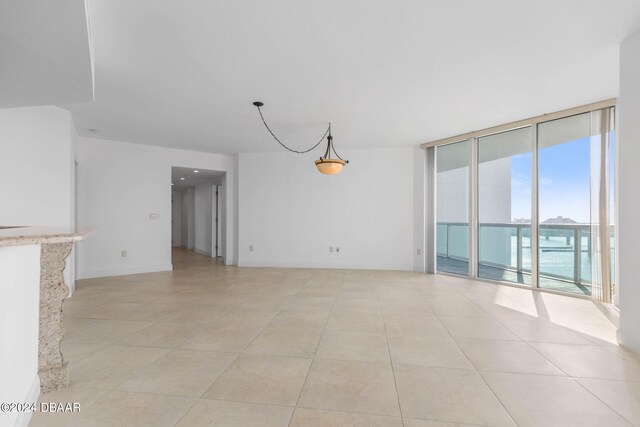 unfurnished living room featuring floor to ceiling windows and light tile patterned floors