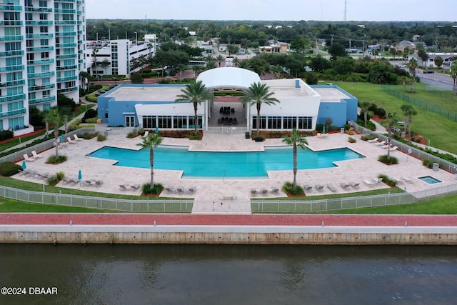 view of swimming pool featuring a water view and a patio