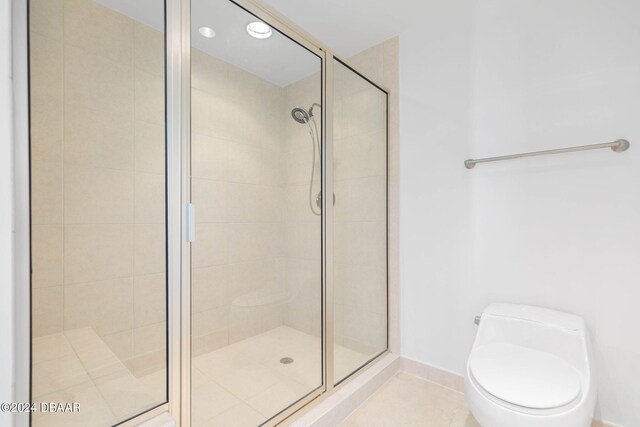 bathroom with toilet, tile patterned flooring, and a shower with shower door