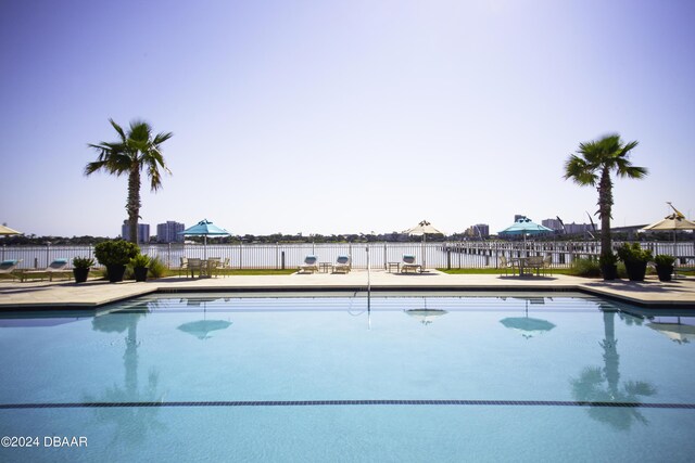 231 Riverside Dr Unit 1209-1, Daytona Beach, FL 32117 - view of pool featuring fence, a water view, and a patio