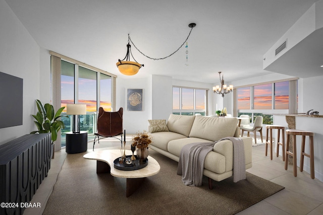 tiled living room featuring a notable chandelier and a healthy amount of sunlight