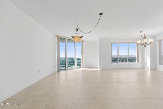 empty room featuring light tile patterned flooring and an inviting chandelier