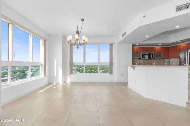 231 Riverside Dr Unit 1209-1, Daytona Beach, FL 32117 - kitchen featuring stainless steel appliances, a chandelier, light tile patterned floors, baseboards, and light stone counters